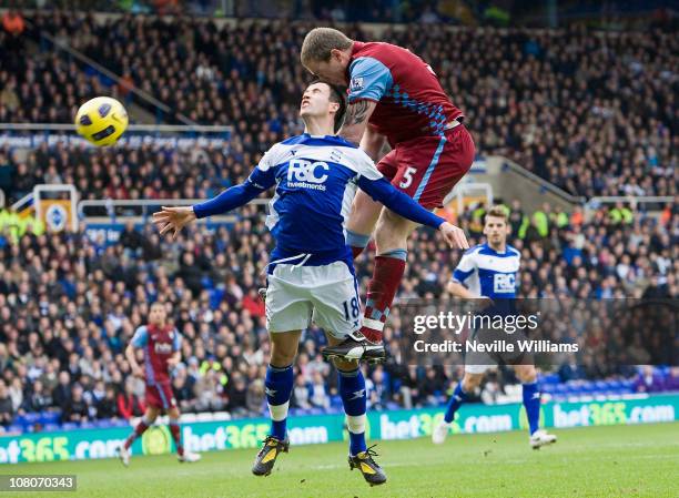 Richard Dunne of Aston Villa heads towards goal with Keith Fahey of Birmingham City challenging on January 16, 2011 in Birmingham, England.