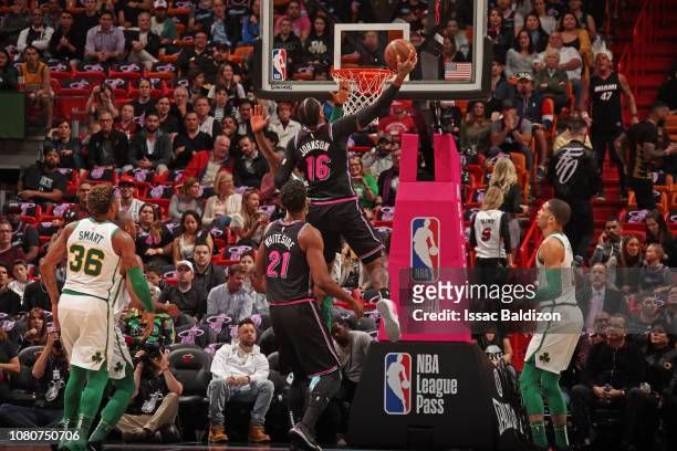 James Johnson of the Miami Heat dunks the ball while guarded by Kyrie Irving of the Boston Celtics on January 10, 2019 at American Airlines Arena in...