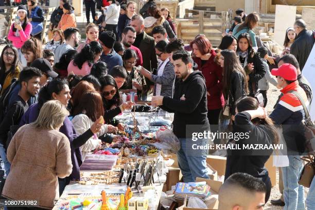 This picture taken on January 11, 2019 shows Christian pilgirms buying rosaries and other religious items at a pop-up bazaar at the Church of Saint...