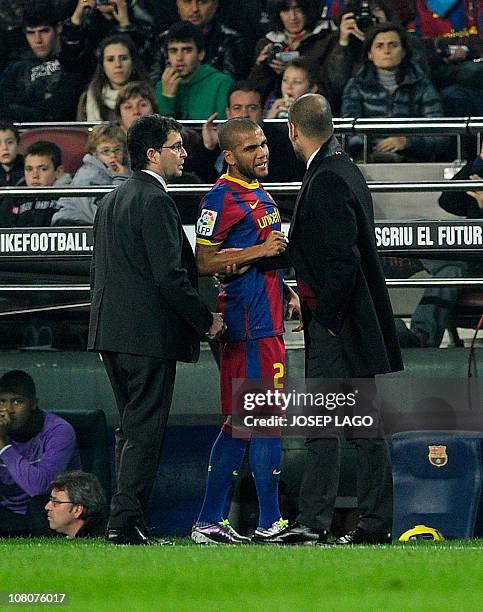 Barcelona's Brazilian defender Daniel Alves chats with Barcelona's coach Josep Guardiola as he leaves the pitch after being injured during the...
