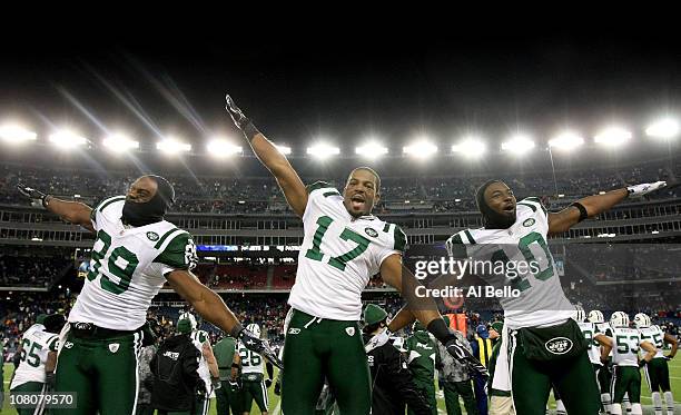 Jerricho Cotchery, Braylon Edwards and Santonio Holmes of the New York Jets celebrate their 28 to 21 victory over the New England Patriots during...