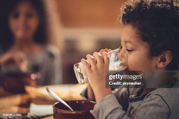 little african american boy drinking fresh milk from a glass. - boy drinking milk stock pictures, royalty-free photos & images