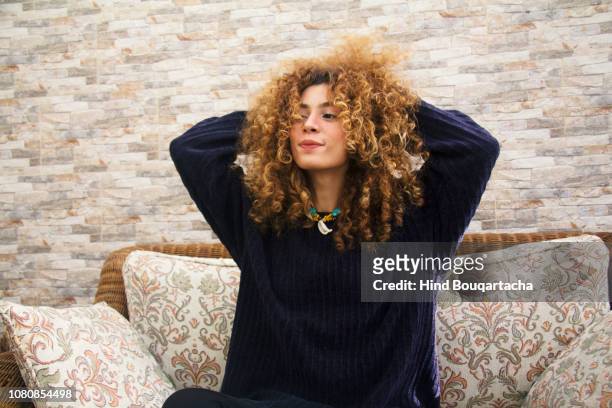 jeune femme joue avec ces cheveux bouclés - bouclé foto e immagini stock