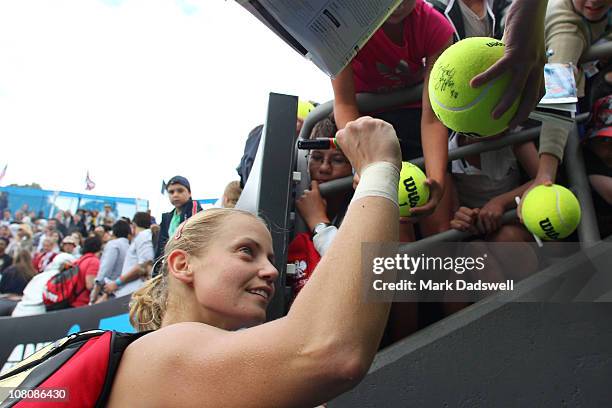 Jelena Dokic of Australia signs fans tennis balls following her victory in her first round match against Zuzana Ondraskova of Czech Republic during...