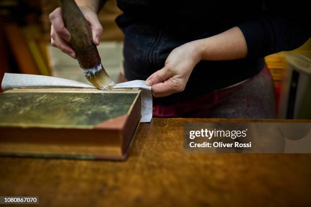 close-up of bookbinder restoring old book - reliures photos et images de collection