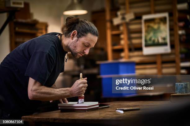 bookbinder in workshop working on a book - reliure de livre photos et images de collection