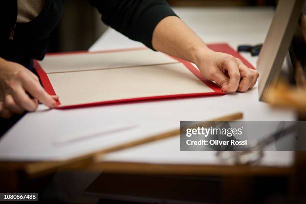 close-up of bookbinder working on paper in workshop - reliure de livre photos et images de collection