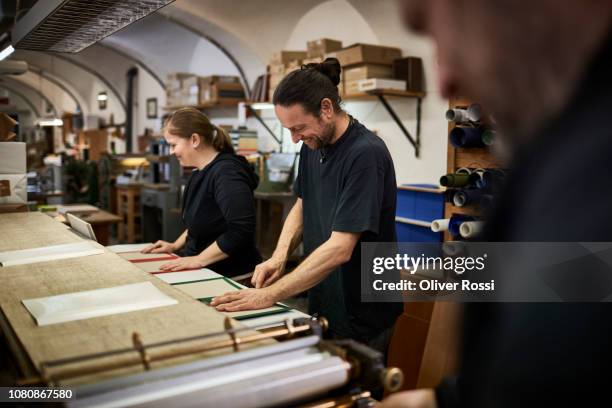 smiling male and female bookbinder working in workshop - reliure de livre photos et images de collection