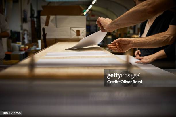 close-up of male and female bookbinder working together in workshop - book binding stock pictures, royalty-free photos & images