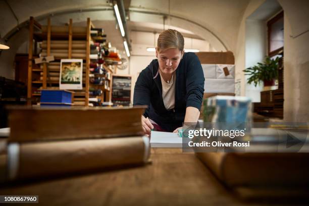 female bookbinder at work in workshop - reliures photos et images de collection