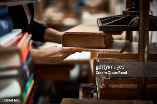 close-up of bookbinder in workshop pressing book - reliure de livre photos et images de collection