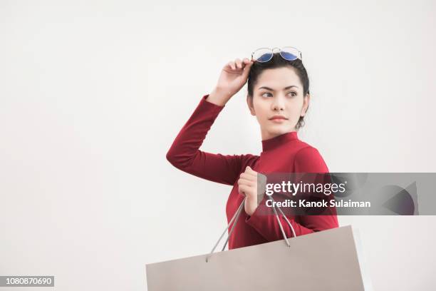 portrait of smiling woman holding shopping bag against white background - shopping bag isolated stock pictures, royalty-free photos & images