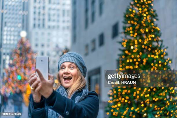 クリスマスでのスマート フォン selfie を取って女性 - ロックフェラーセンターのクリスマスツリー ストックフォトと画像