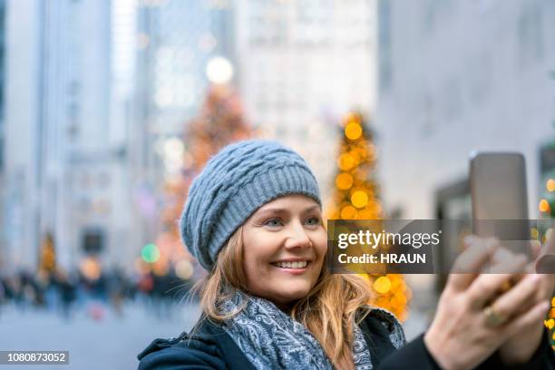 市でスマート フォン selfie 幸せな女 - ロックフェラーセンターのクリスマスツリー ストックフォトと画像