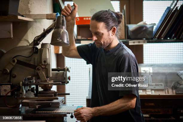 bookbinder using machine in workshop - reliure de livre photos et images de collection