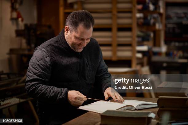 bookbinder working on book in workshop - reliure de livre photos et images de collection
