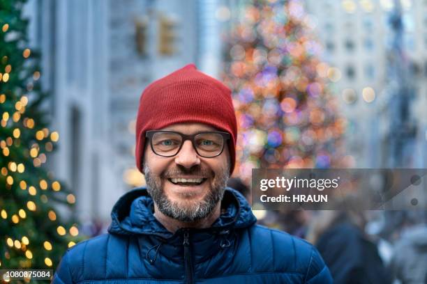 portret van een volwassen man in stad glimlachen tijdens kerstmis. - christmas newyork stockfoto's en -beelden