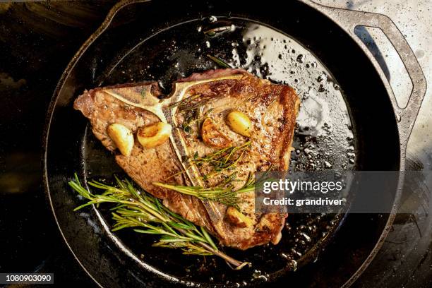 juicy t-bone beef steak in a cast iron skillet - cast iron stock pictures, royalty-free photos & images