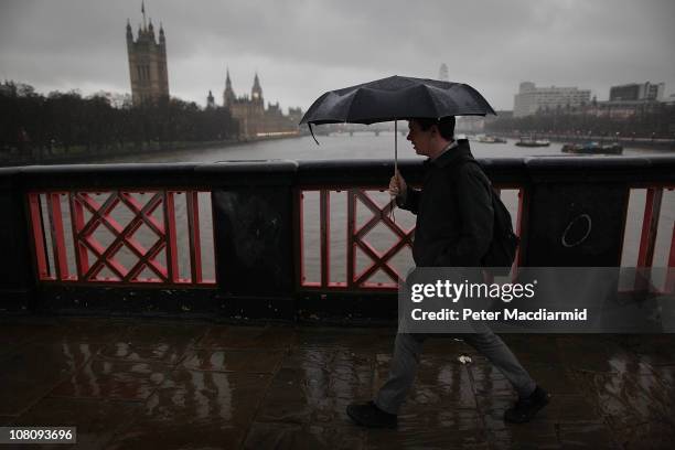 Man walks across Lambeth Bridge in the rain on "blue Monday" on January 17, 2011 in London, England. Psychologists say a number of factors including...