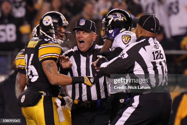 Safety Ed Reed of the Baltimore Ravens and wide receiver Hines Ward of the Pittsburgh Steelers are separated by a referee after a play during the AFC...