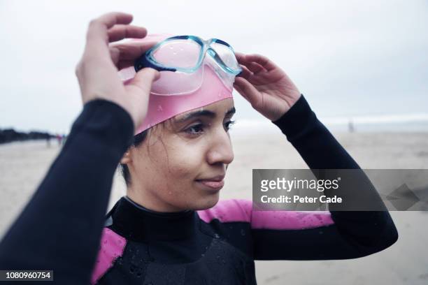 Young woman on beach in winter ready to swim