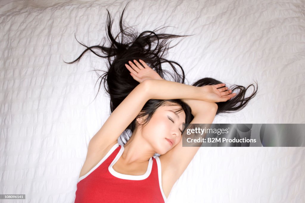 Young woman sleeping on bed