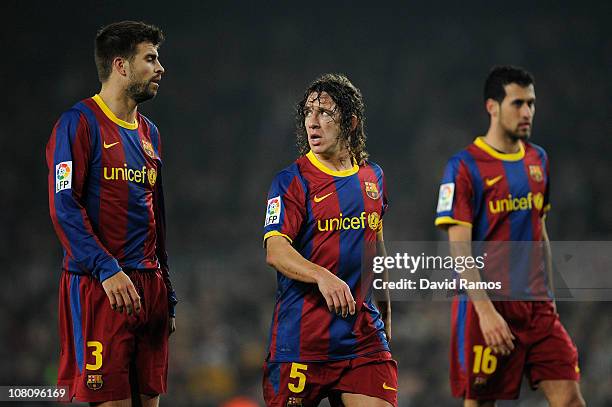 Gerard Pique , Carles Puyol and Sergio Busquets of FC Barcelona look on during the La Liga match between FC Barcelona and Malaga at Nou Camp on...