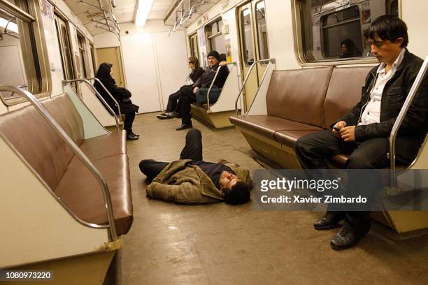 Drunk man lying down on his back unconscious in a metro train while other passengers do not care on April 2, 2011 in Moscow, Russia