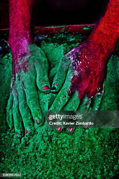 Close-up of human hand with colorful powder paint, Holi, with a container to sell the gulal powder on March 26 at Mathura, India.