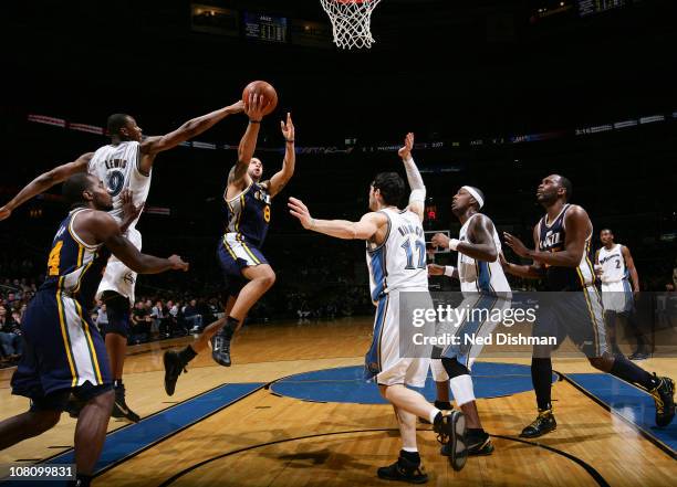 Deron Williams of the Utah Jazz shoots against Rashard Lewis and Kirk Hinrich of the Washington Wizards at the Verizon Center on January 17, 2011 in...