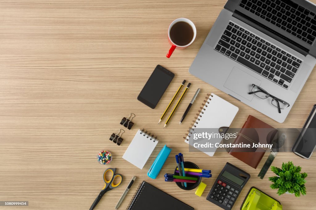 Top View of Laptop, Notebook, Coffee and Office Supply Items on Wood Background