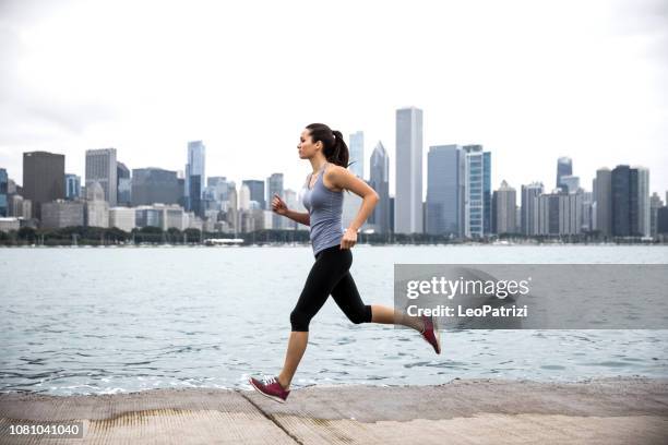 woman exercising outdoors in the city - corrida de rua imagens e fotografias de stock