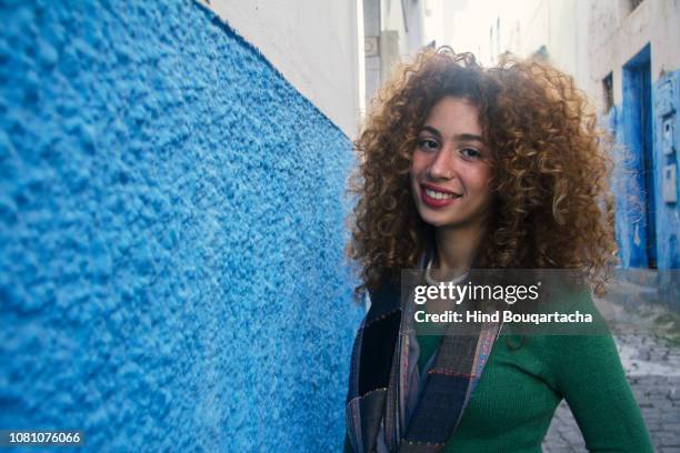 jeune femme avec cheveux bouclés souriante - portrait femme fotografías e imágenes de stock
