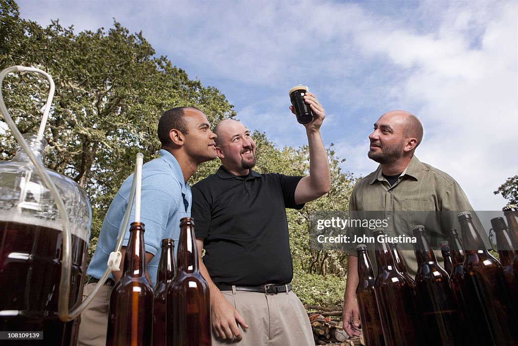 Men looking at the color of their homebrew.