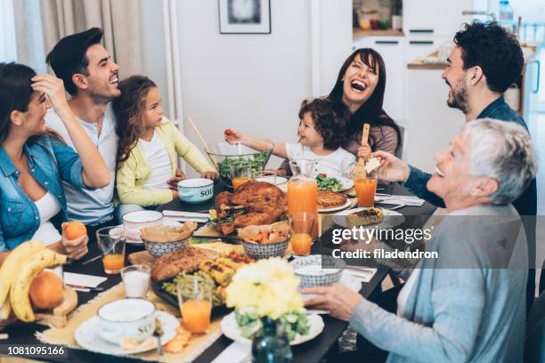 familia comiendo comida de navidad - thanksgiving fotografías e imágenes de stock