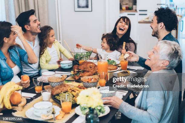 family eating christmas lunch - friendsgiving stock pictures, royalty-free photos & images