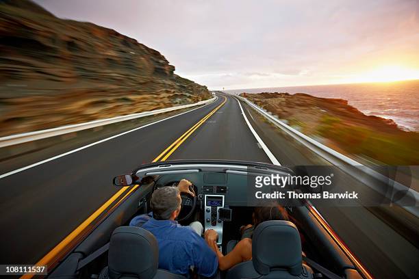 husband and wife driving convertible at sunrise - 2 people back asian imagens e fotografias de stock