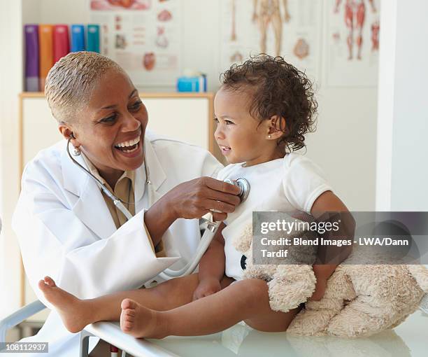 doctor listening to baby's breathing with stethoscope - doctor stethoscope patient whole body stock pictures, royalty-free photos & images