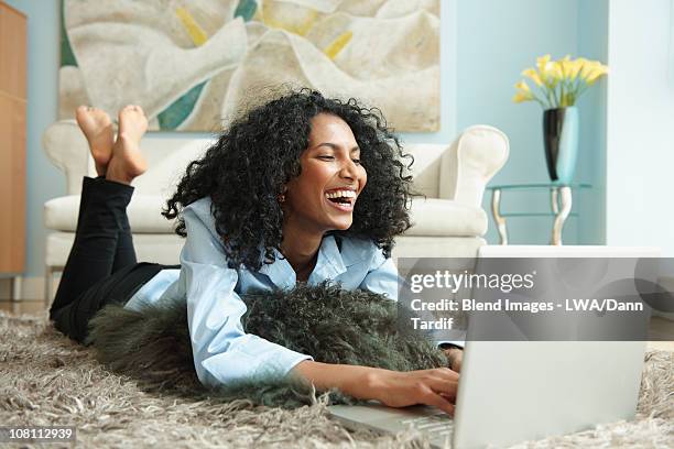 black woman laying on floor using laptop - de bruços imagens e fotografias de stock