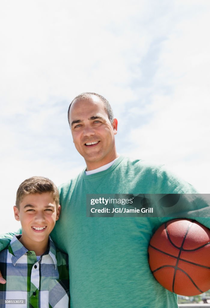 Hispanic father and son with basketball