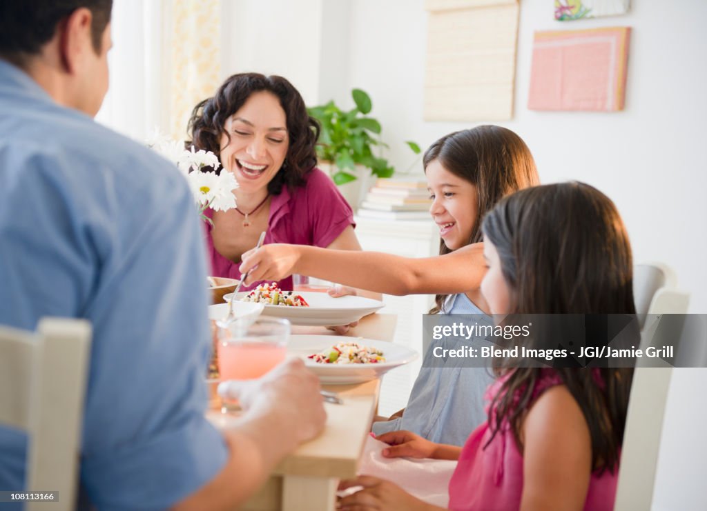 Laughing family having dinner together
