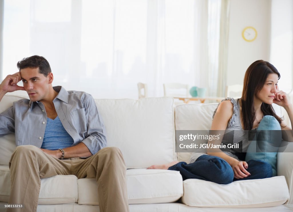 Angry mixed race couple having argument on sofa