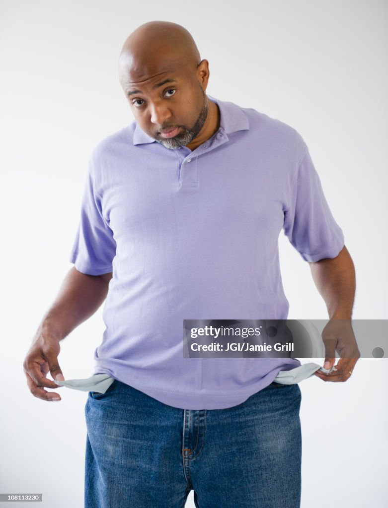 Sad African American holding out empty pockets