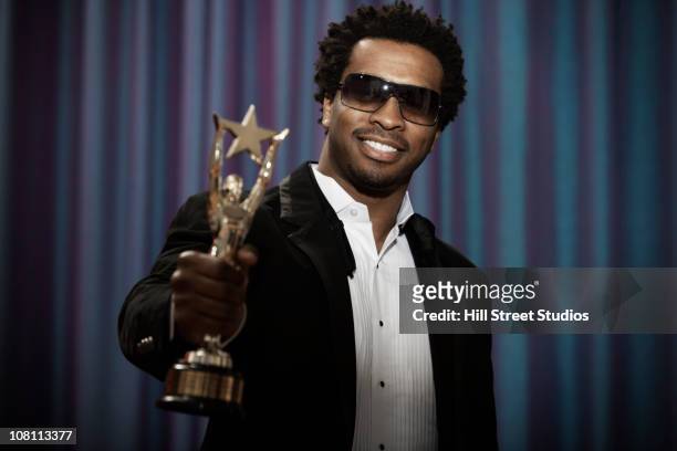 sorridente uomo in smoking nero con trofeo premi - style award 2010 foto e immagini stock