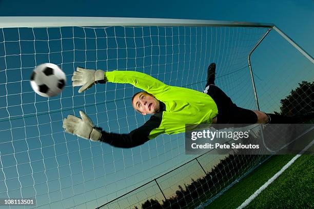 caucasian goalie deflecting soccer ball - soccer goal fotografías e imágenes de stock