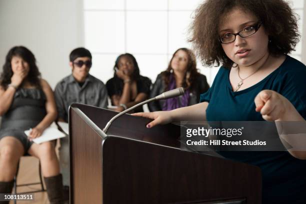 teenage girl giving speech to classmates - debate imagens e fotografias de stock