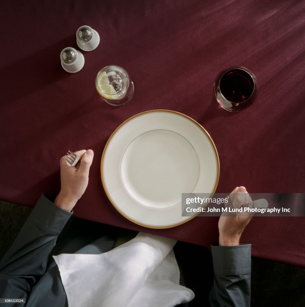 Caucasian woman waiting in front of empty plate