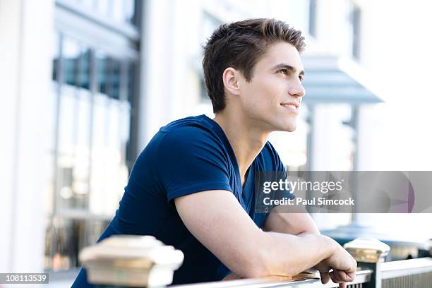 smiling caucasian man leaning on railing - leaning ストックフォトと画像