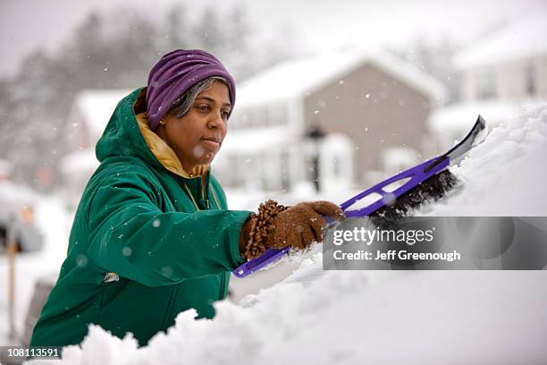 afrikanische amerikanische frau schnee aus windschutzscheibe abschaben - eiskratzer stock-fotos und bilder