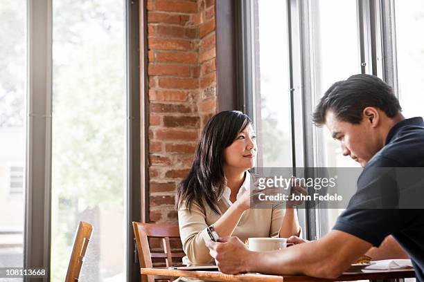 chinese couple drinking coffee in cafe - enjoying coffee cafe morning light stock pictures, royalty-free photos & images